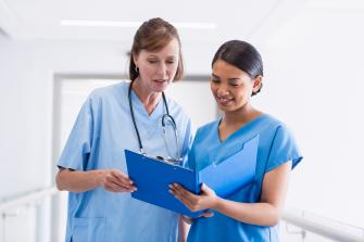 Nurses discussing over clipboard